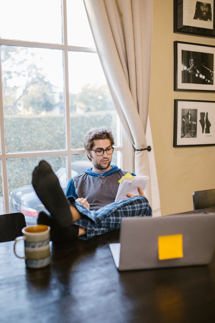 A Man Reading Papers While His Feet on the Table